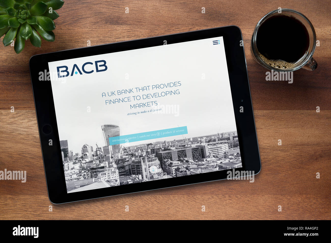 Il sito della British Arab Commercial Bank (BACB) è visto su un tablet iPad, su di un tavolo di legno (solo uso editoriale). Foto Stock