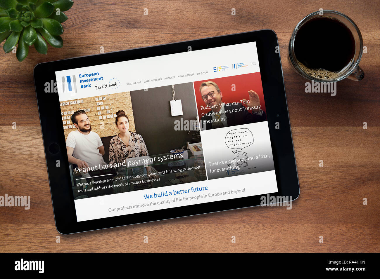 Il sito web della Banca europea per gli investimenti (BEI) è visto su un tablet iPad, su di un tavolo di legno (solo uso editoriale). Foto Stock