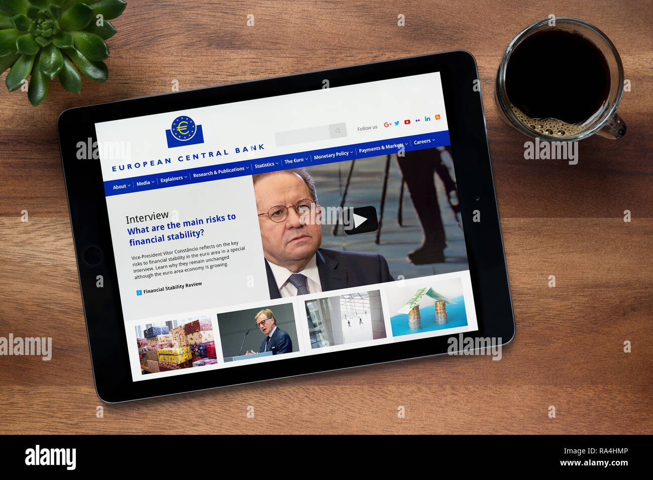 Il sito web della Banca centrale europea è visto su un tablet iPad, su di un tavolo di legno lungo con un caffè espresso e una pianta di casa (solo uso editoriale) Foto Stock