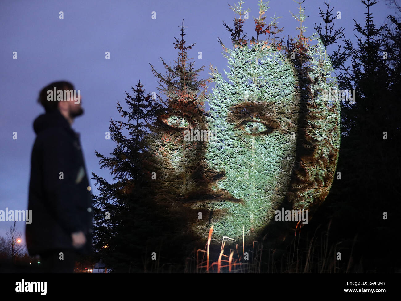 Steven McConnachie visualizza una proiezione di Libra su alberi all'Fire & Luce Cosmica di fortune: un illuminato, magica esperienza all'aperto tenutosi presso l'Helix a Falkirk. Foto Stock