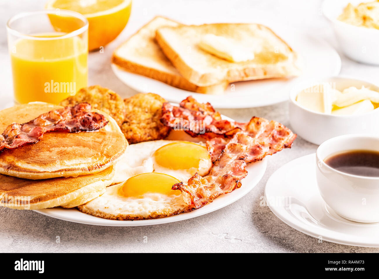 Una sana colazione Americana completa con uova pancetta pancake e Latkes, il fuoco selettivo. Foto Stock