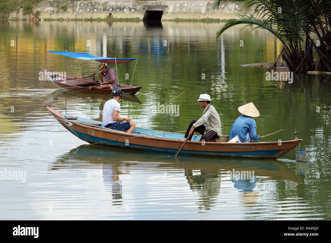 La vita quotidiana della scena locale di uomini la pesca di cibo nella piccola barca tradizionale su Thu Bon River. Hoi An, Quang Nam Provincia, Vietnam Asia Foto Stock