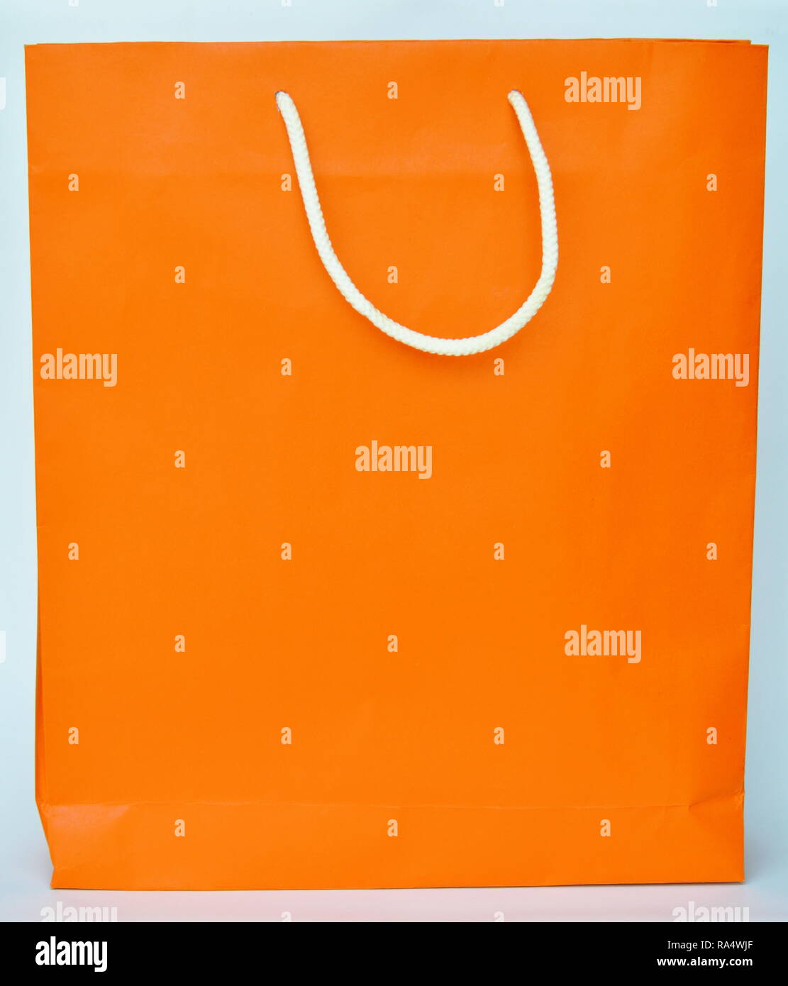 Arancione sacchetto di carta bianca con manico di nylon Foto Stock