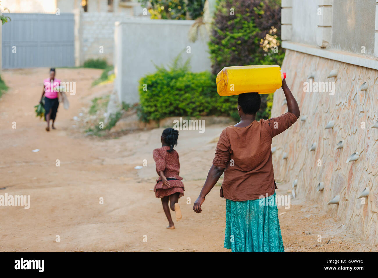 Donna che trasporta l'acqua a Entebbe, Uganda Foto Stock