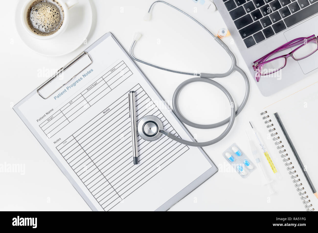 Il decorso del paziente nota con uno stetoscopio e accessori per medico sul tavolo bianco, Health care concept Foto Stock
