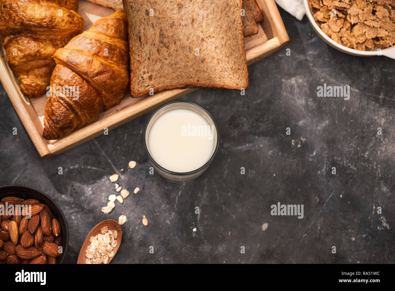 La prima colazione con pane tostato e croissant. Il latte in una bottiglia di vetro. Buon inizio di giornata. Buon giorno Foto Stock