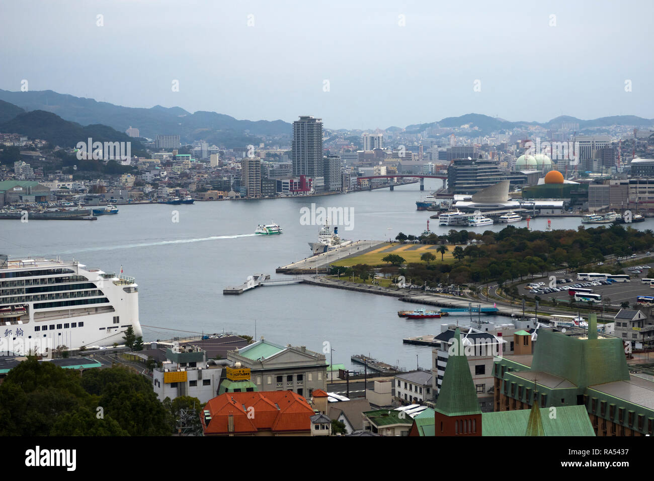 Nagasaki, Giappone - 26 Ottobre 2018: Nagasaki port con traghetti e cruiseboats circondato da montagne Foto Stock