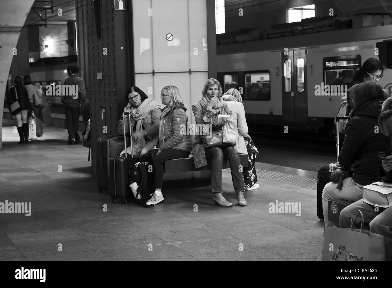I passeggeri di attendere per un treno nella stazione ferroviaria Anversa, Belgio Foto Stock