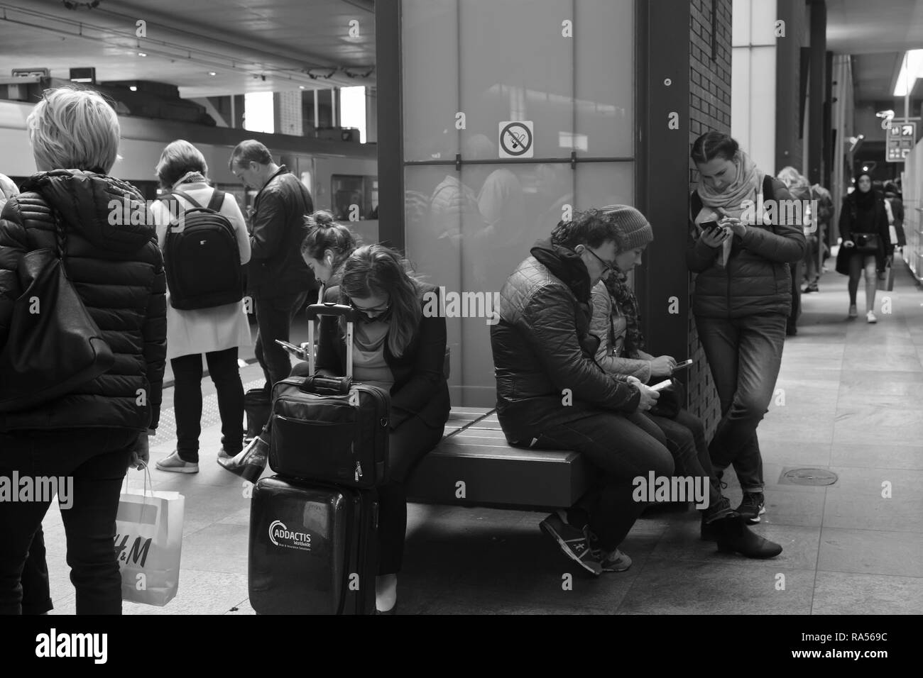 I passeggeri di attendere per un treno nella stazione ferroviaria Anversa, Belgio Foto Stock