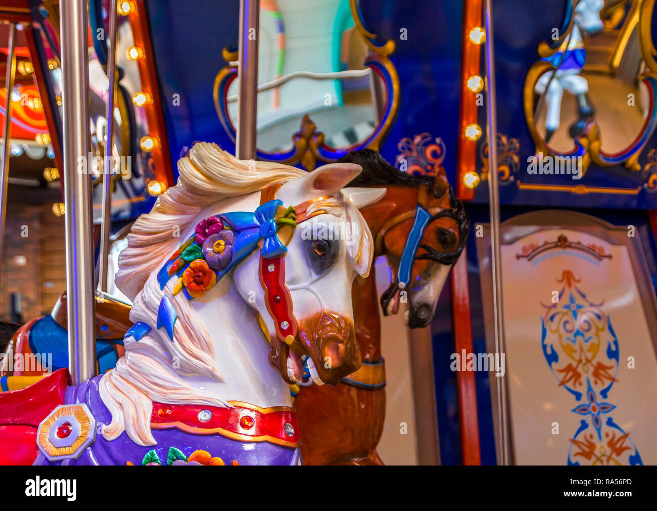 Un dipinto e coloratissima giostra cavallo in un parco di divertimenti Foto Stock