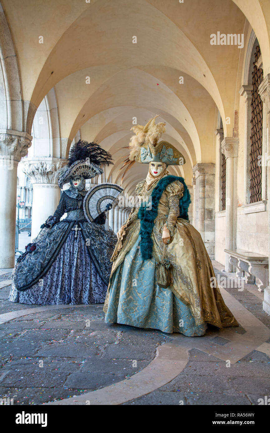 Costumi e maschere veneziane in argento nero e oro sotto la Galleria dei Dogi Palazzo per il Carnevale di Venezia, Venezia Italia Foto Stock