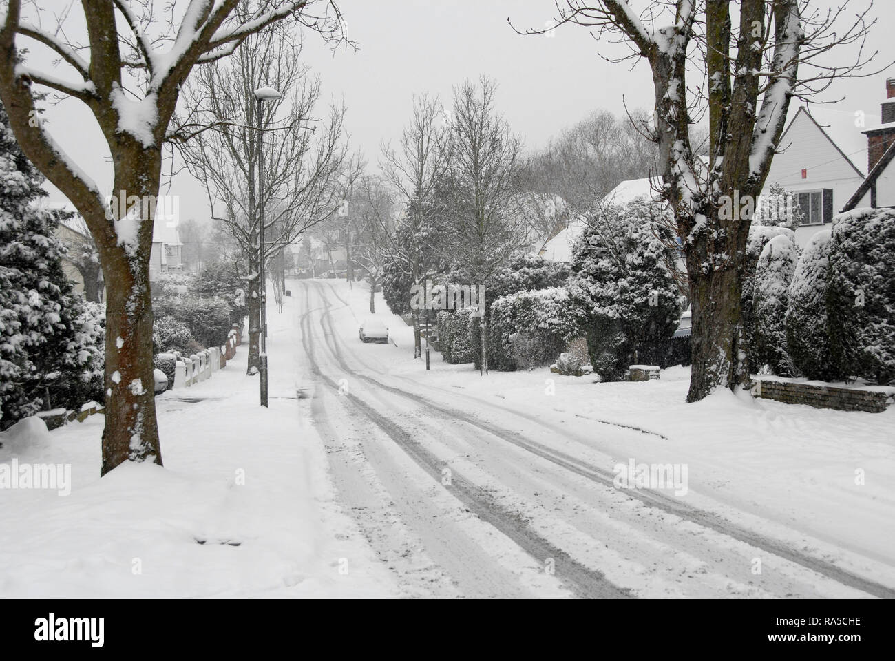 La caduta di neve sulla suburbana locale strada residenziale, Inghilterra Foto Stock