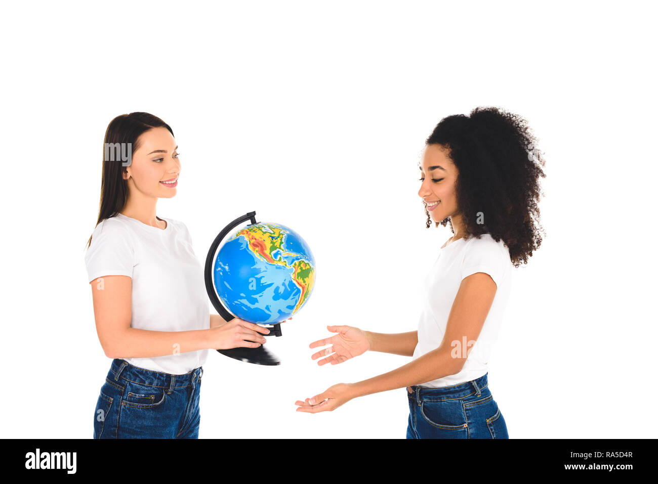 Donna sorridente holding globe nelle vicinanze African American Girl isolato su bianco Foto Stock