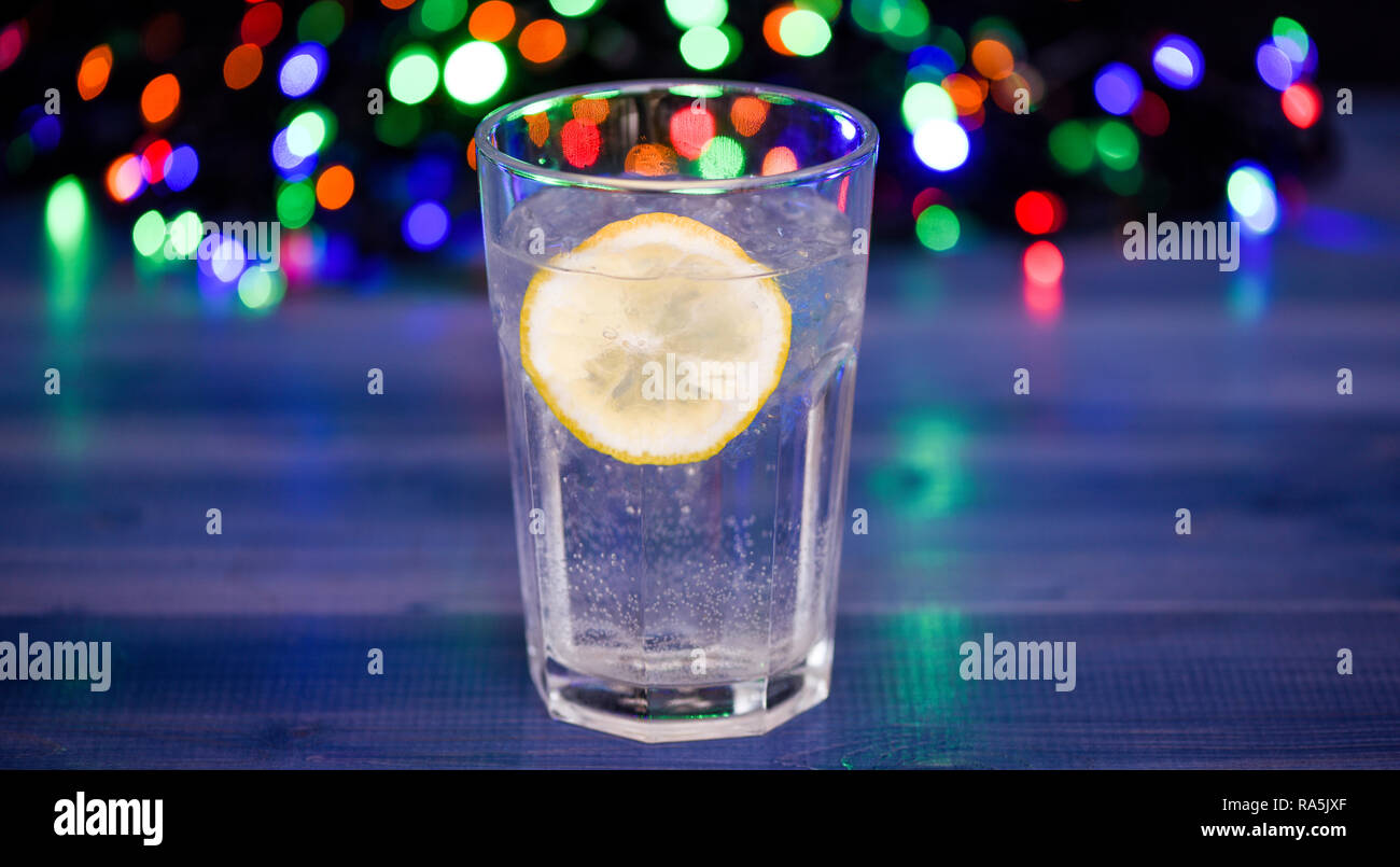Detox Dopo La Festa D Inverno Health Care Concetto Cosa Bere Sulla Festa Di Natale Bicchiere Da Cocktail Con Acqua E La Fetta Di Limone Defocalizzata Ghirlanda Di Luci Detox Drink Per Sentirsi