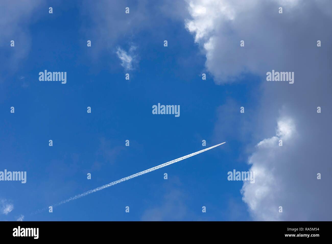 Aeroplano con strisce di condensazione nella nuvola blu cielo, Germania Foto Stock