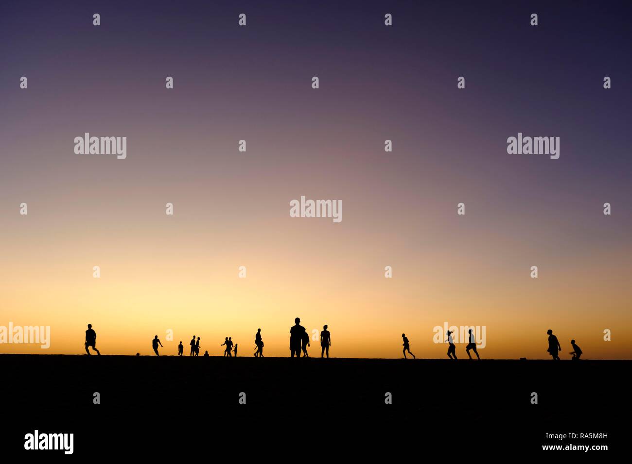 Silhouette di bambini che giocano a calcio, crepuscolo, Somone laguna, regione di Thiès, Senegal Foto Stock