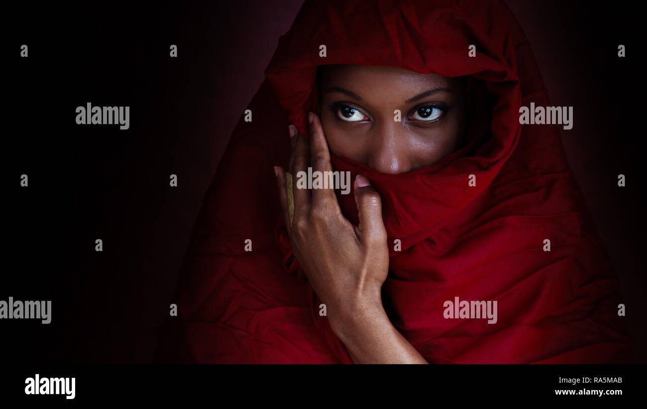 Ritratto di donna, riempie il suo volto con un panno rosso, Germania Foto Stock