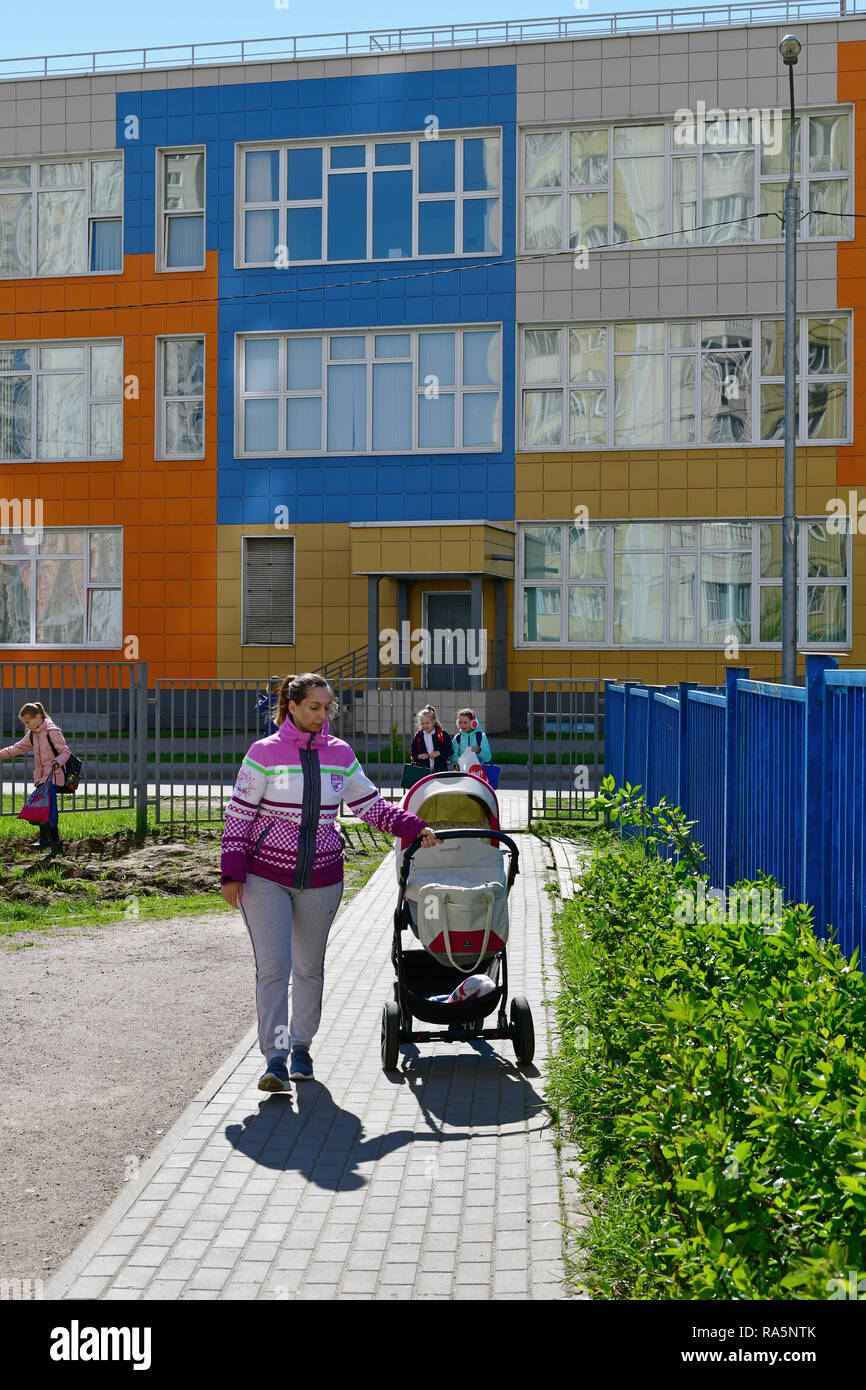 Khimki,Russia - Maggio 10. 2018. La mamma con un bambino carrello vicino la scuola media di una educazione generale Foto Stock