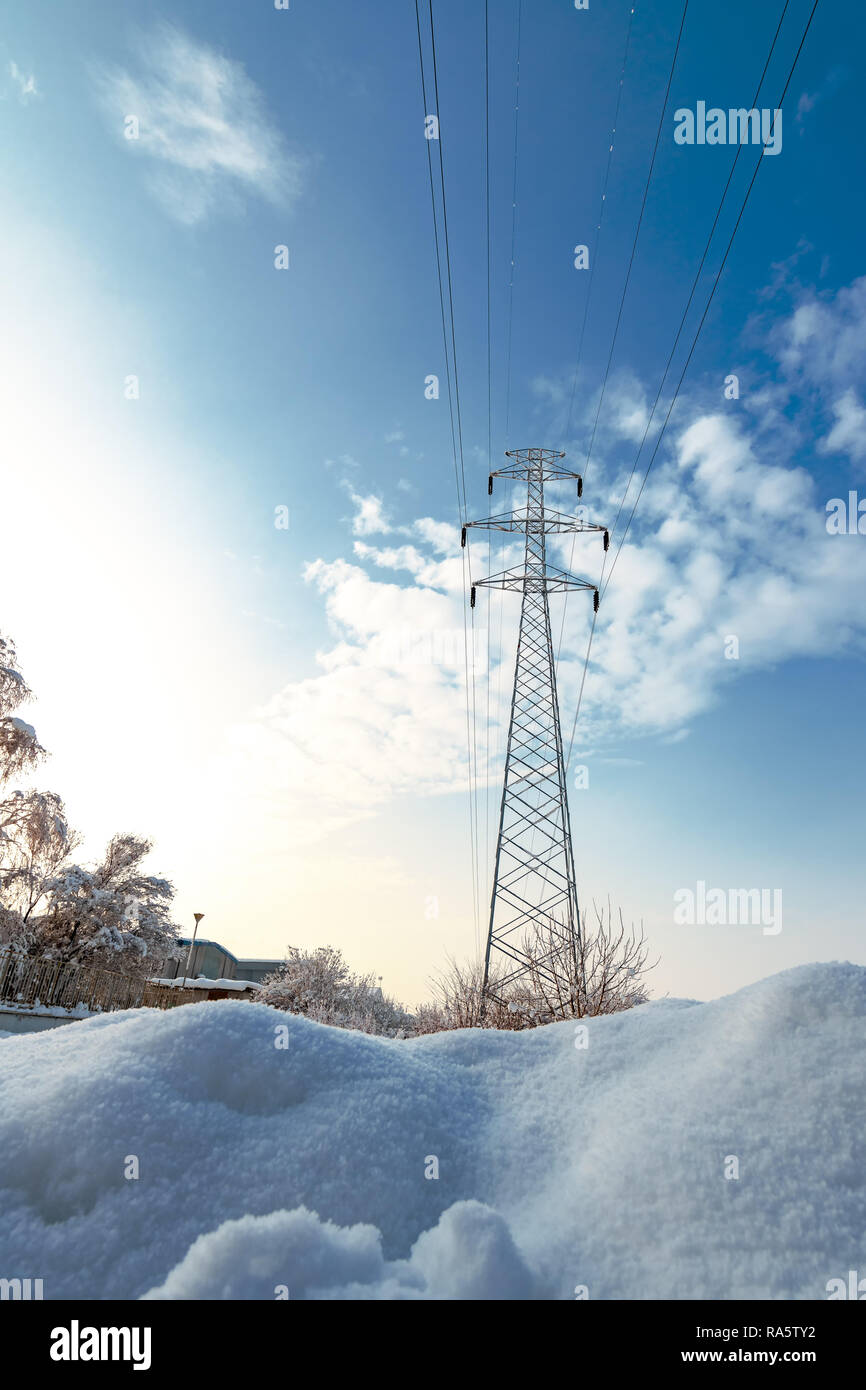 Pilone di elettricità nella neve, il paesaggio invernale con lonely pole per la trasmissione di potenza Foto Stock