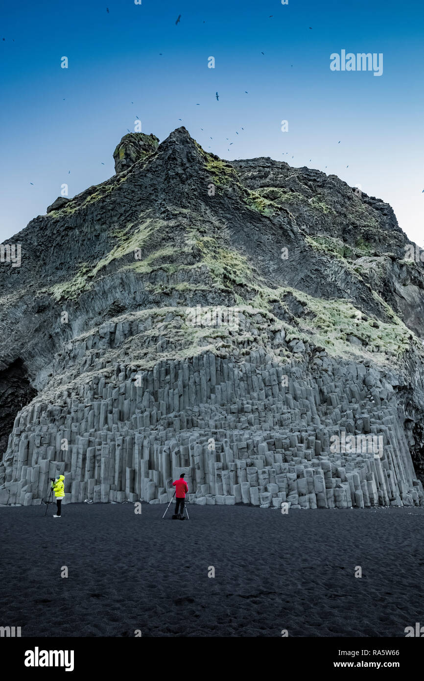 Fotografare la rupe di colonne di basalto lungo la Reynisfjara spiaggia di sabbia nera Islanda [Nessun modello di rilascio; disponibile per editoriale solo licenza] Foto Stock