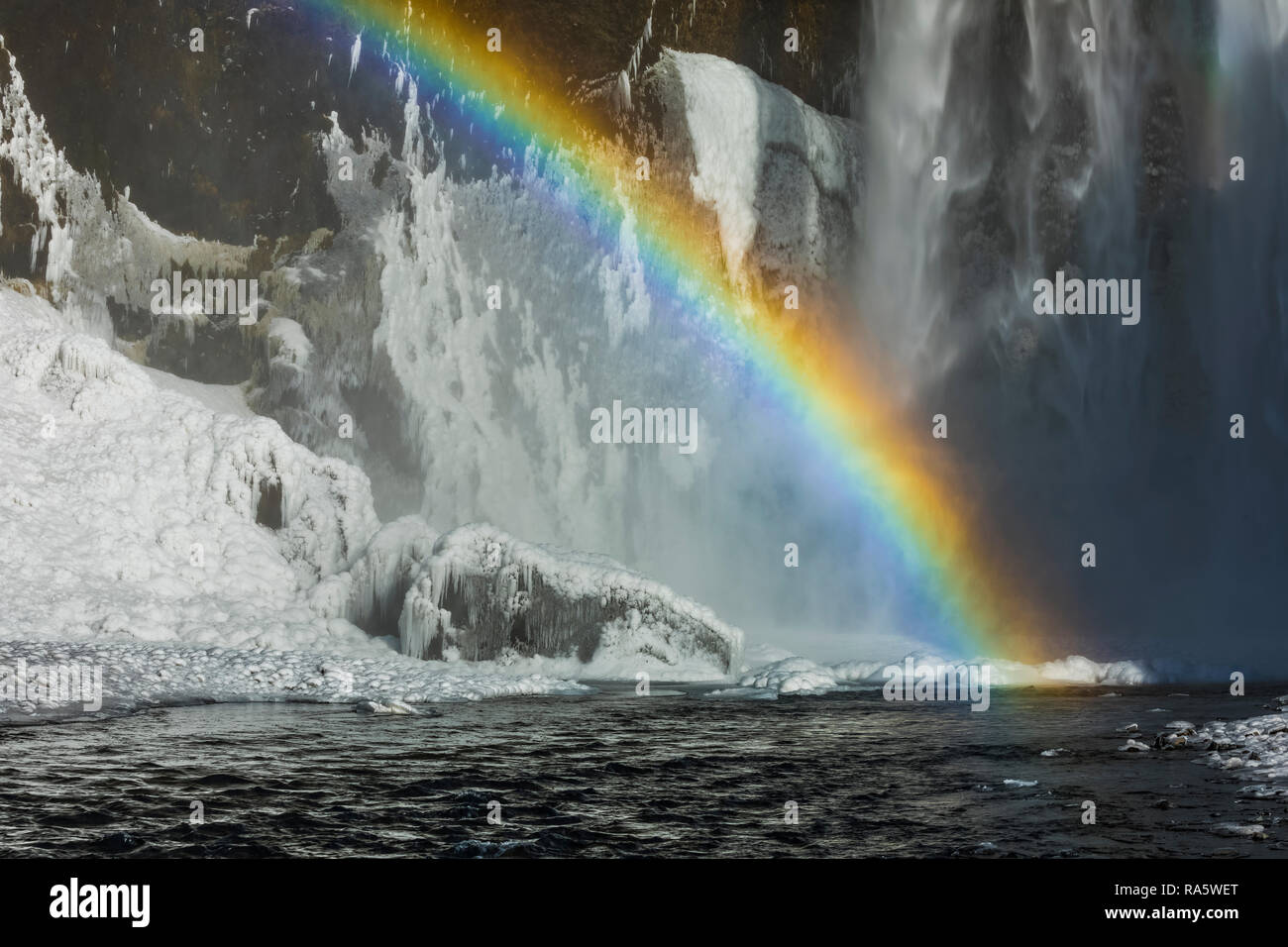 Skógafoss, una bellissima cascata con un arcobaleno in spray, lungo il fiume Skógá e caduta ex scogliere sul mare, lungo la costa sud dell'Islanda i Foto Stock