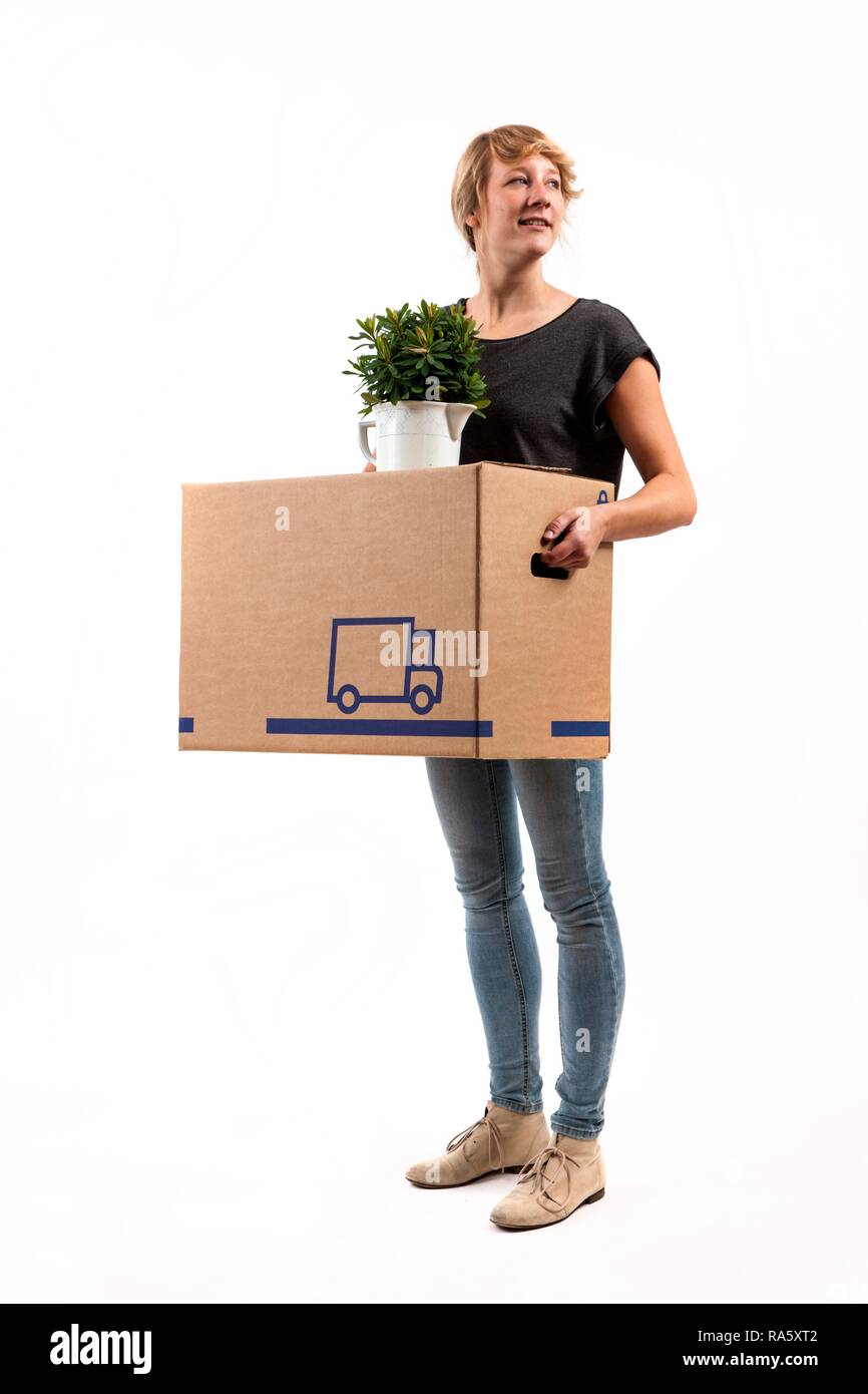 Giovane donna che porta una scatola di movimentazione e una pianta di casa Foto Stock