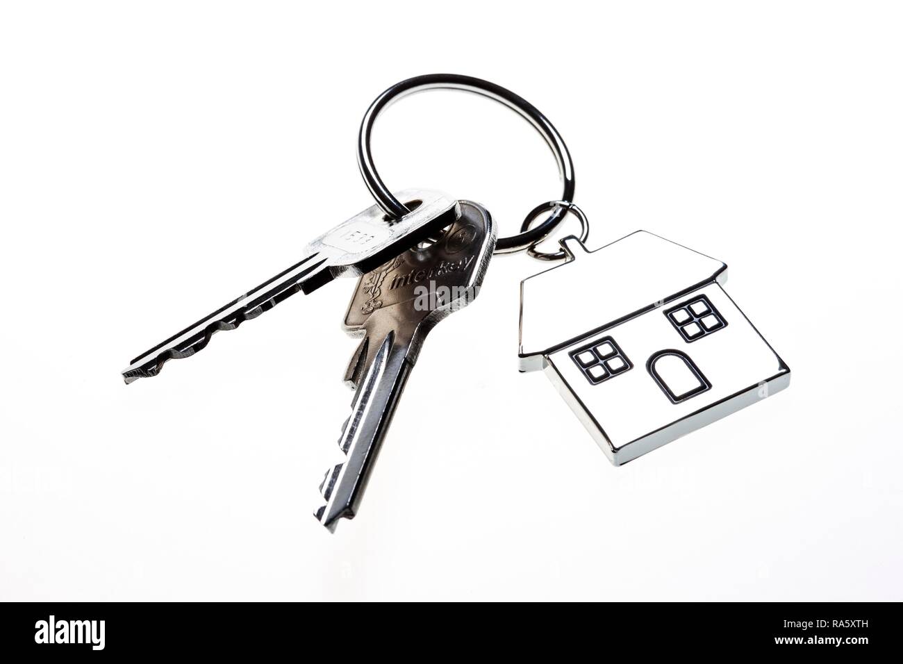 Due chiavi con una chiave in metallo a forma di etichetta come una casa, immagine simbolica per la casa, real estate Foto Stock