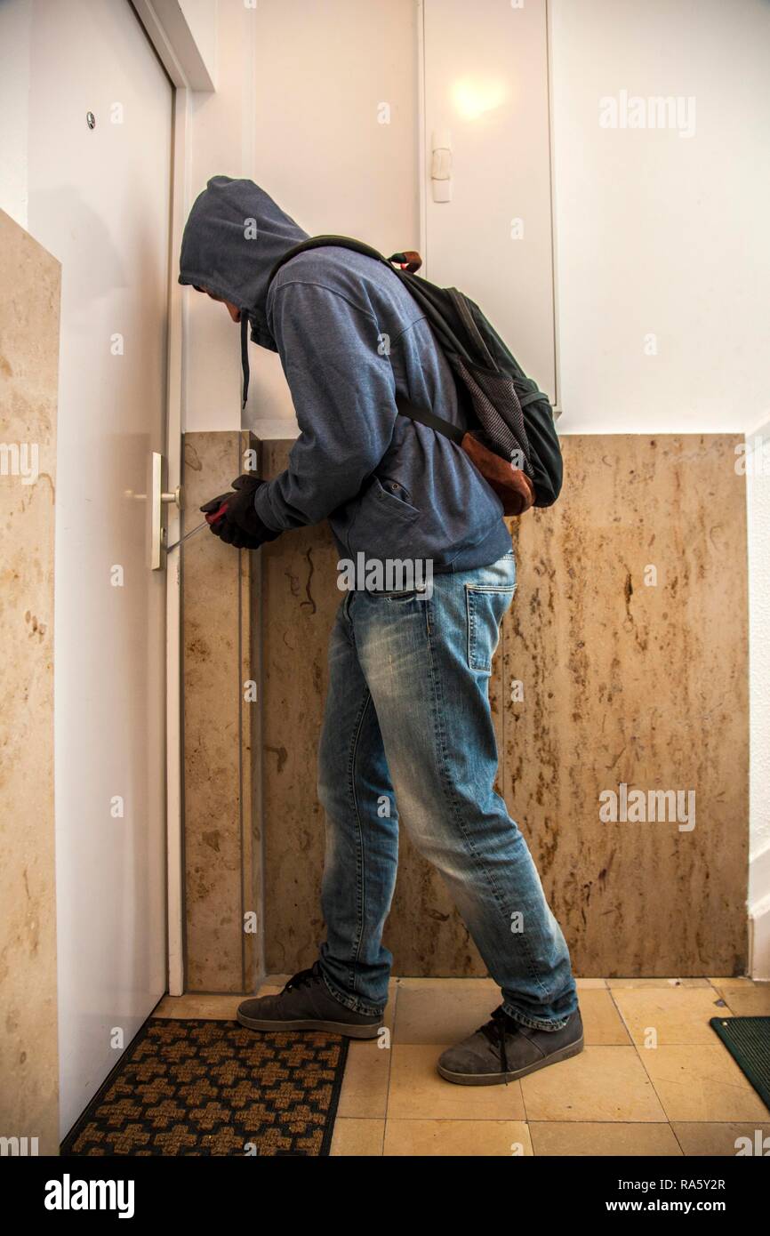Ladro fa leva per aprire una porta di un appartamento Foto Stock
