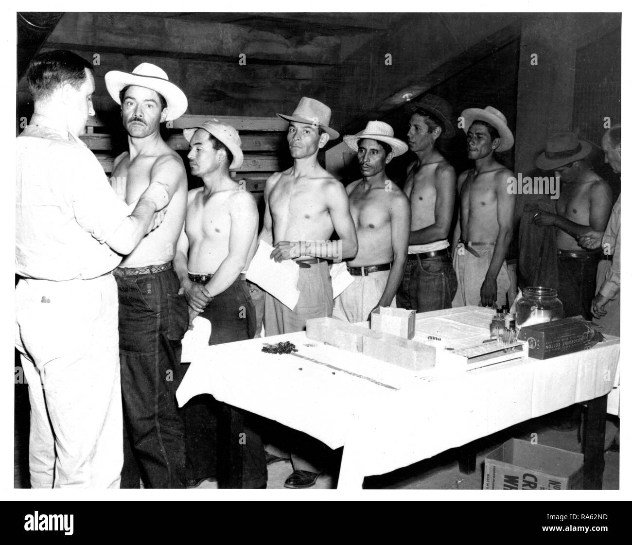 Servizio sanitario pubblico funzionario messicano vaccinare i lavoratori migranti a El Paso, Texas ca. 1963 Foto Stock