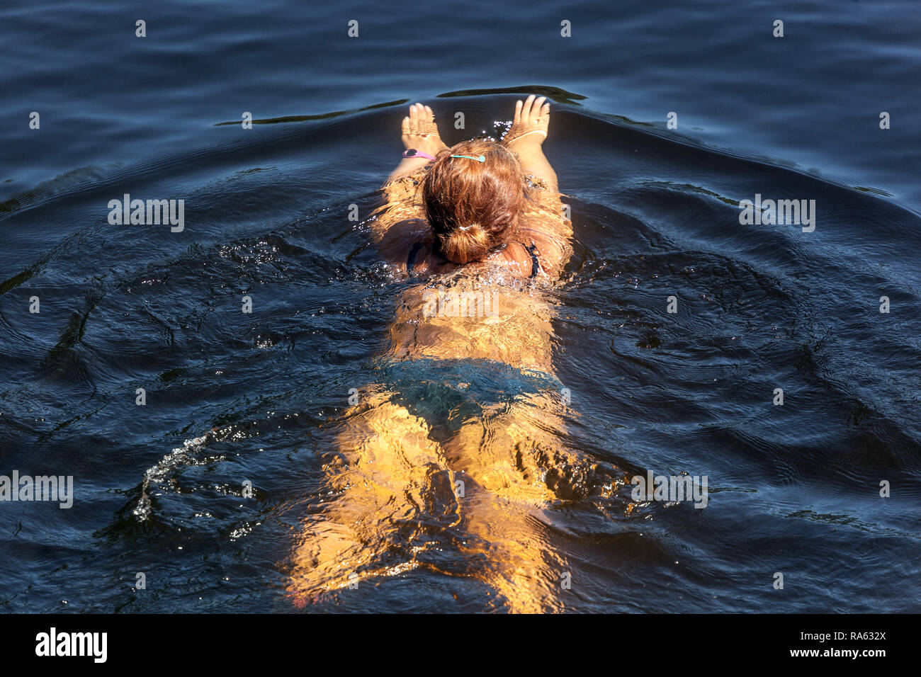 Donna galleggiante sul fiume Foto Stock