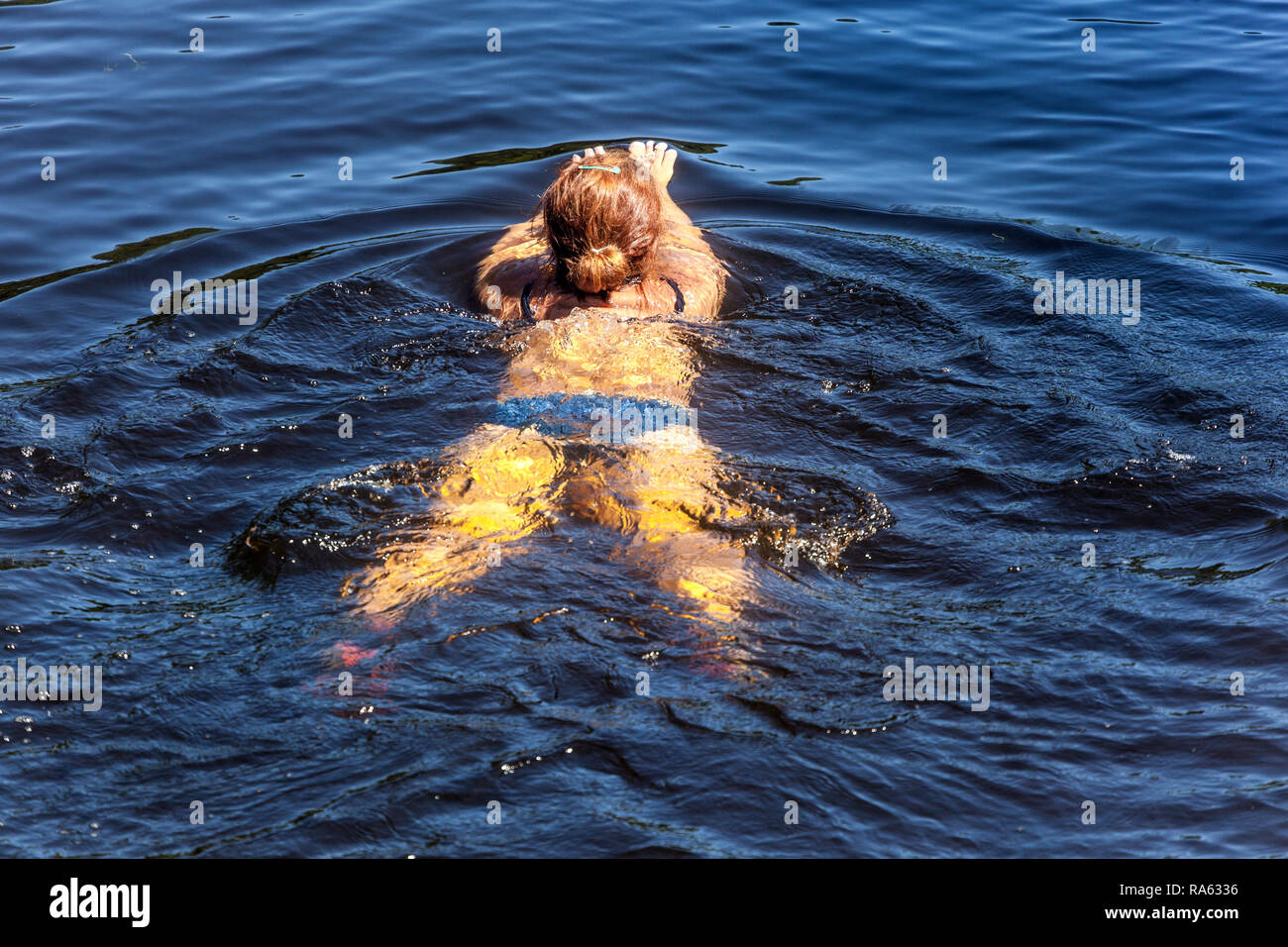 Donna galleggiante sul fiume Foto Stock