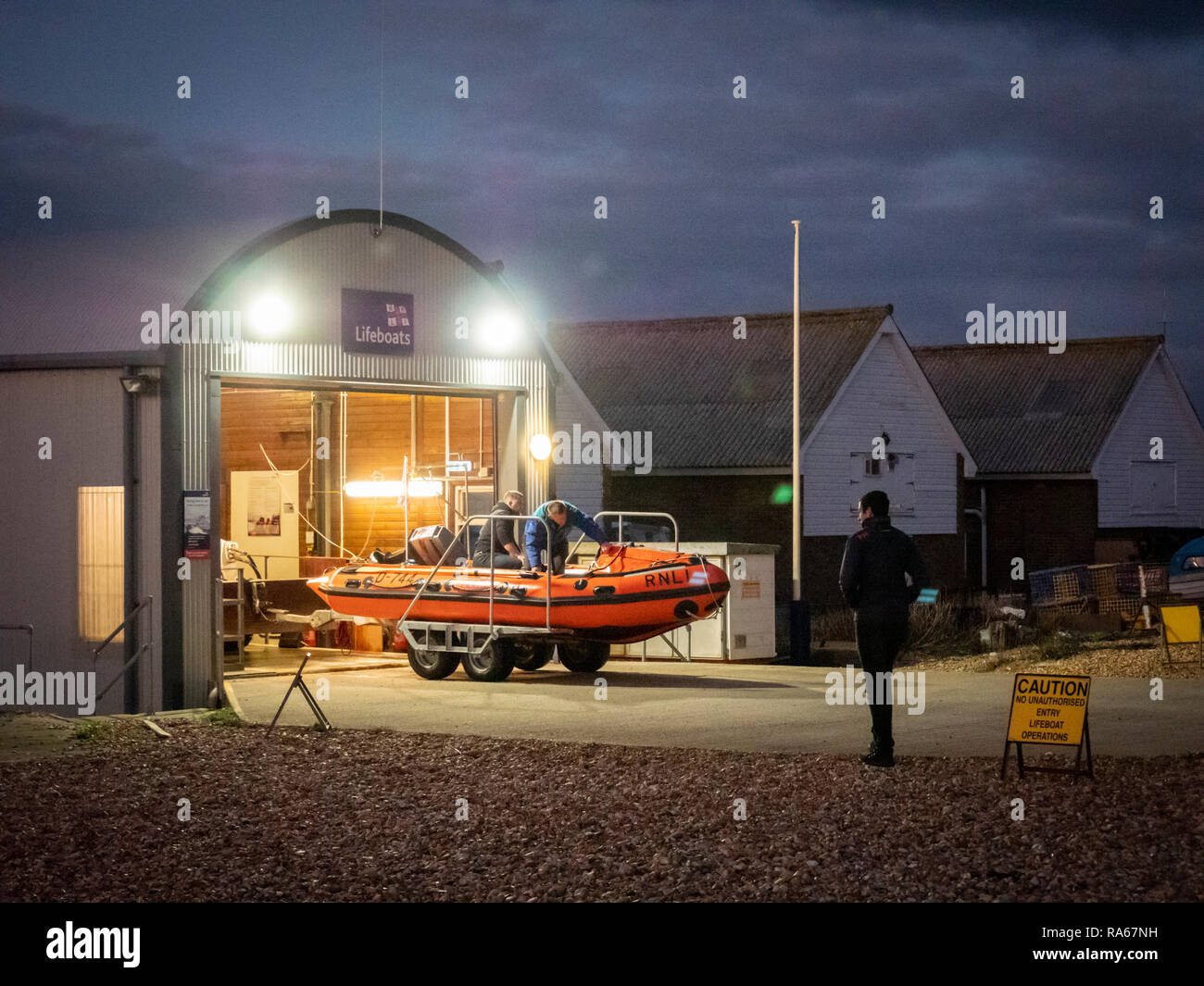 Eastbourne, East Sussex, Regno Unito, 1 gennaio 2019. Il RNLI scialuppa di salvataggio è lanciato dalla spiaggia sulla costa sud appena come esso diventa scuro sulla costa sud stazione balneare. L'equipaggio spinto la classe D scialuppa di salvataggio costiera lungo la spiaggia di ciottoli con un piccolo trattore e sped fuori nelle tenebre. Credito: Julian Eales/Alamy Live News Foto Stock