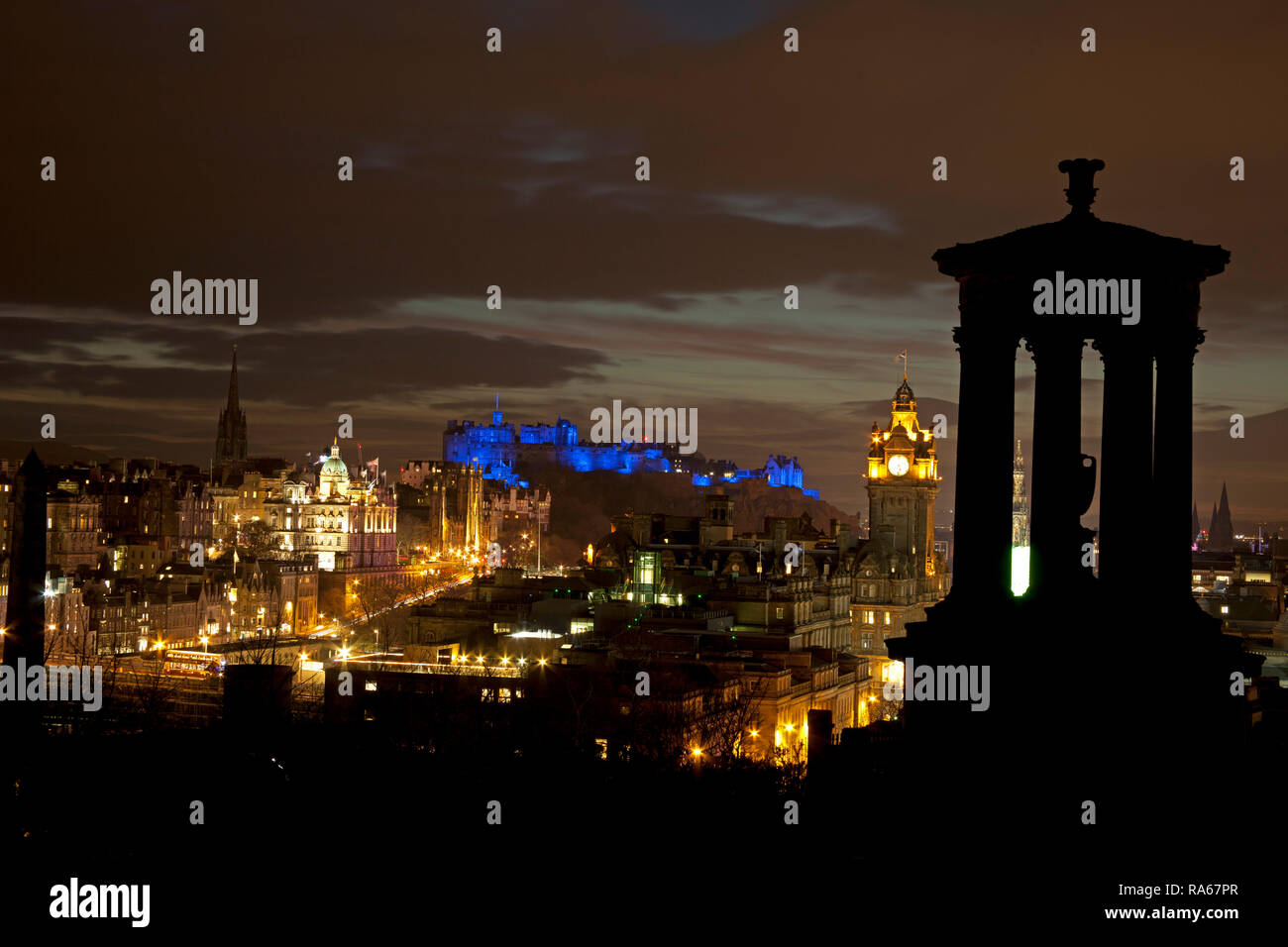 Edimburgo, Scozia, Regno Unito. 01 gennaio 2019. Skyline della capitale illuminata dal centro città da Calton Hill con il castello illuminato blu con proiettori per il nuovo anno. Foto Stock