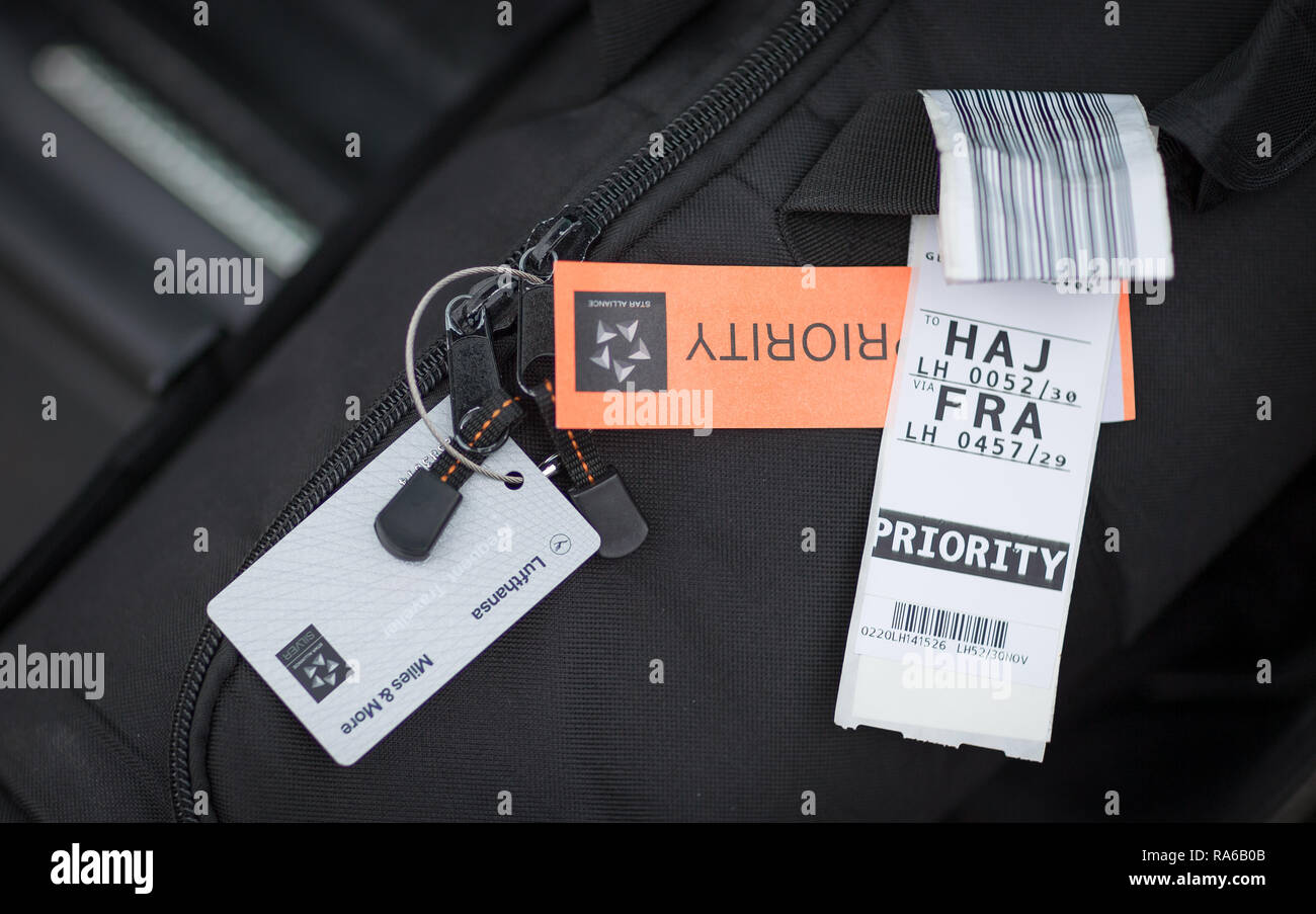 19 dicembre 2018, Bassa Sassonia, Osnabrück: Illustrazione - un bagaglio etichette con codici a barre si blocca sul manico di una borsa. L'introduzione di etichette RFID è destinato a garantire che un minor numero di pezzi di bagaglio sono persi in volo il bagaglio. Con l aiuto di un piccolo chip, che è integrato nell'usuale fascia, il Bagaglio Controllato per lâ imbarco possono essere trovati e identificati più facilmente. (Zu dpa 'bene sbarcati, valigia passati - con chip RFID contro la perdita di bagagli in volo") Foto: Friso Gentsch/dpa Foto Stock