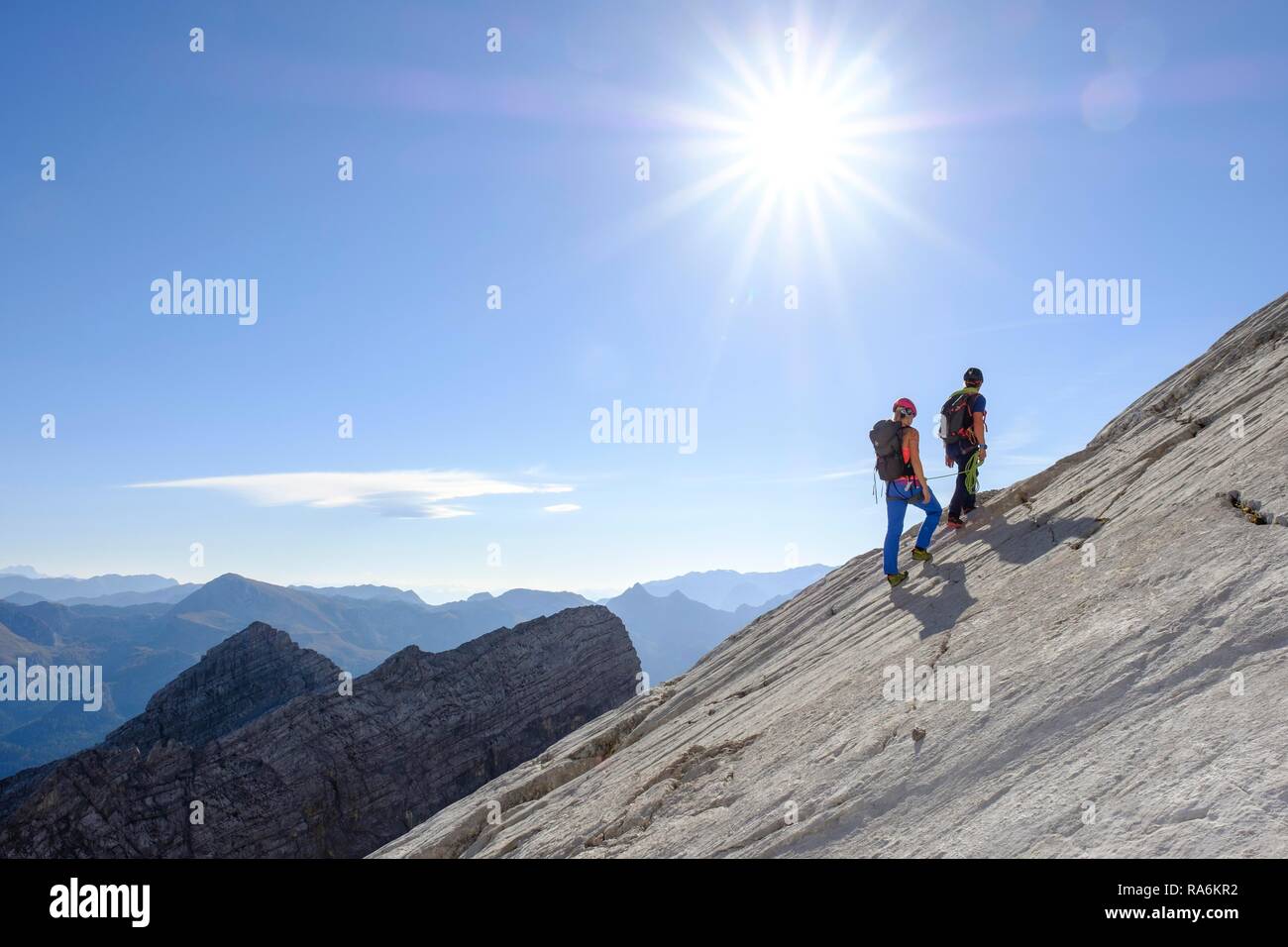 Guida di montagna la guida di una giovane donna su un breve corda attraverso una parete di roccia, Wiederroute, Watzmann, Schönau am Königssee Foto Stock