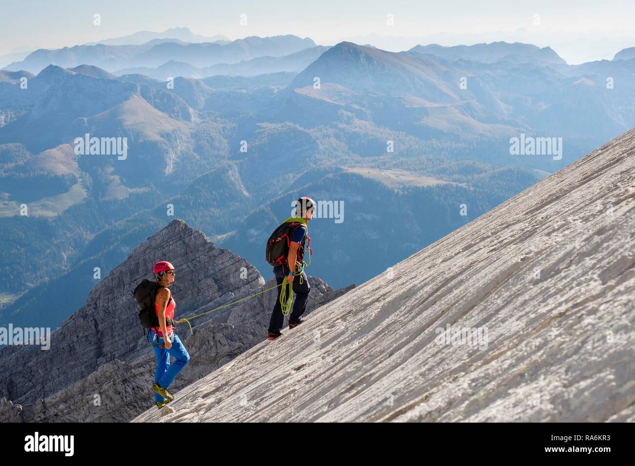 Guida di montagna la guida di una giovane donna su un breve corda attraverso una parete di roccia, Wiederroute, Watzmann, Schönau am Königssee Foto Stock