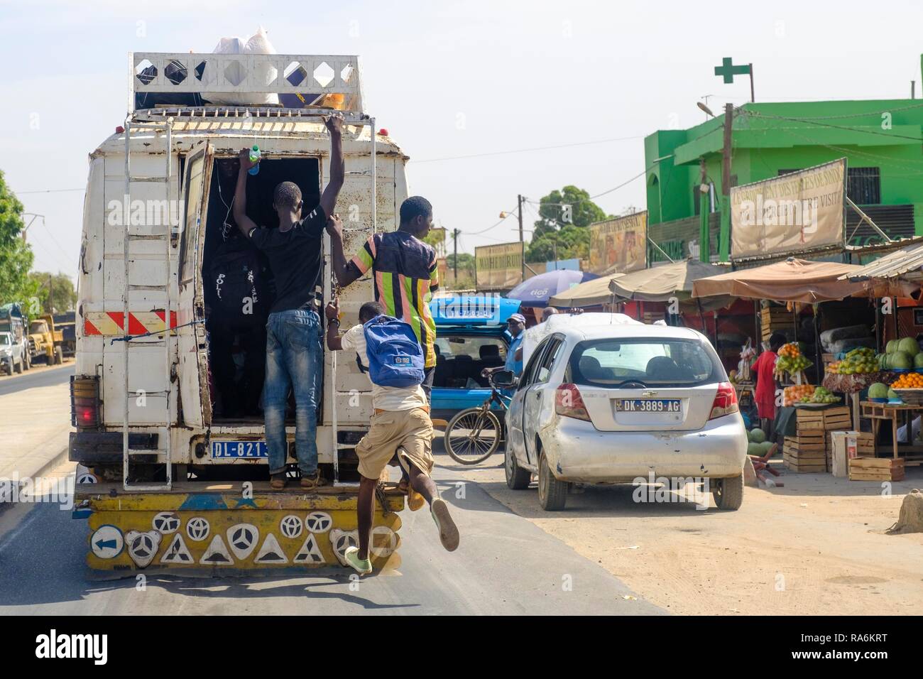 Uomo salta su un bus, Dakar, Senegal Foto Stock