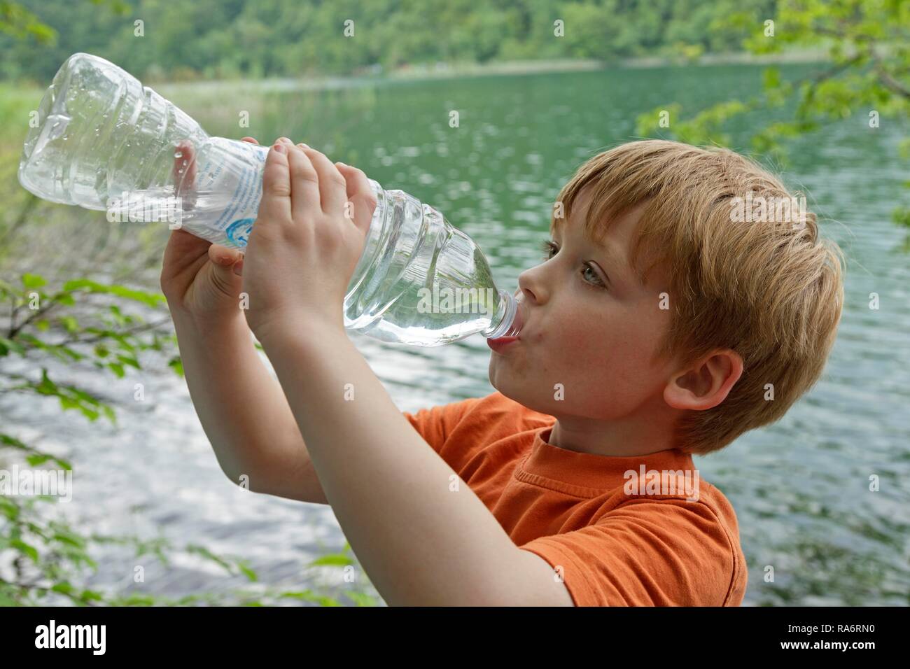 Ragazzo beve l'acqua da una bottiglia di plastica, il Parco Nazionale dei Laghi di Plitvice, Croazia Foto Stock