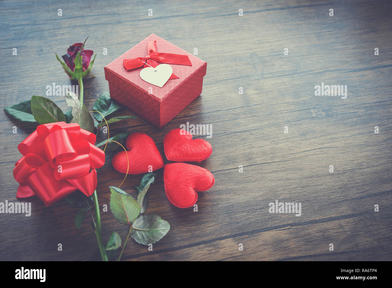 Valentines day gift box red on wood background / Red Heart Valentines day red rose flower and present box ribbon bow on old wooden - Love concept top  Foto Stock
