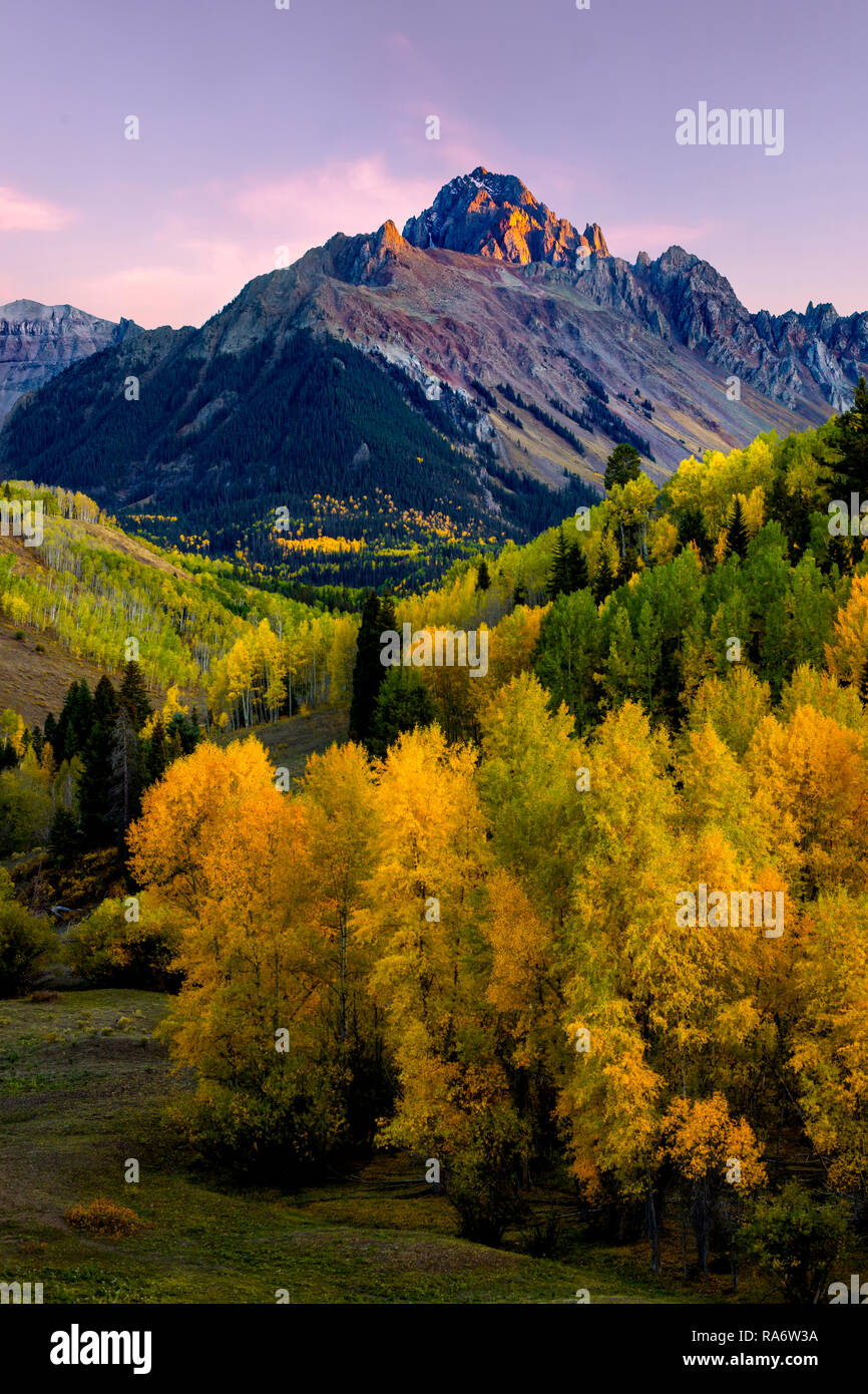 Sunset Glow alpino sul monte Wilson con Golden Aspen nella valle Foto Stock