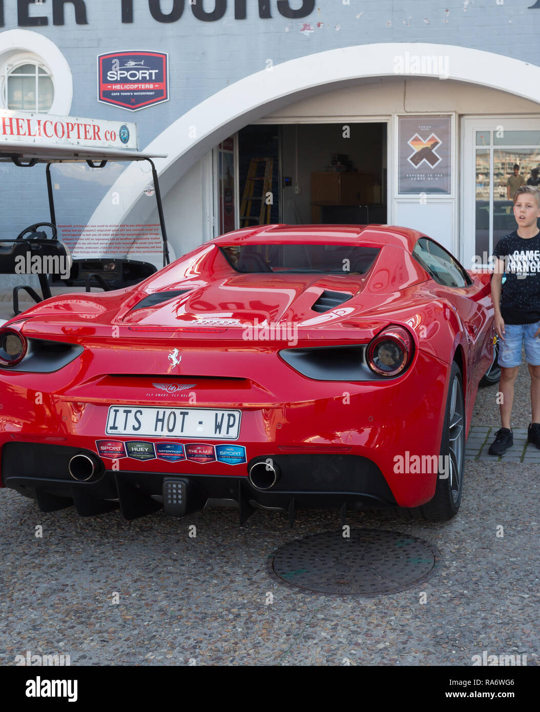 Rosso Ferrari auto personalizzata con numero di targa, il suo caldo, e  Little Boy in piedi accanto ad esso parcheggiato al V & A Waterfront di  Cape Town Foto stock - Alamy