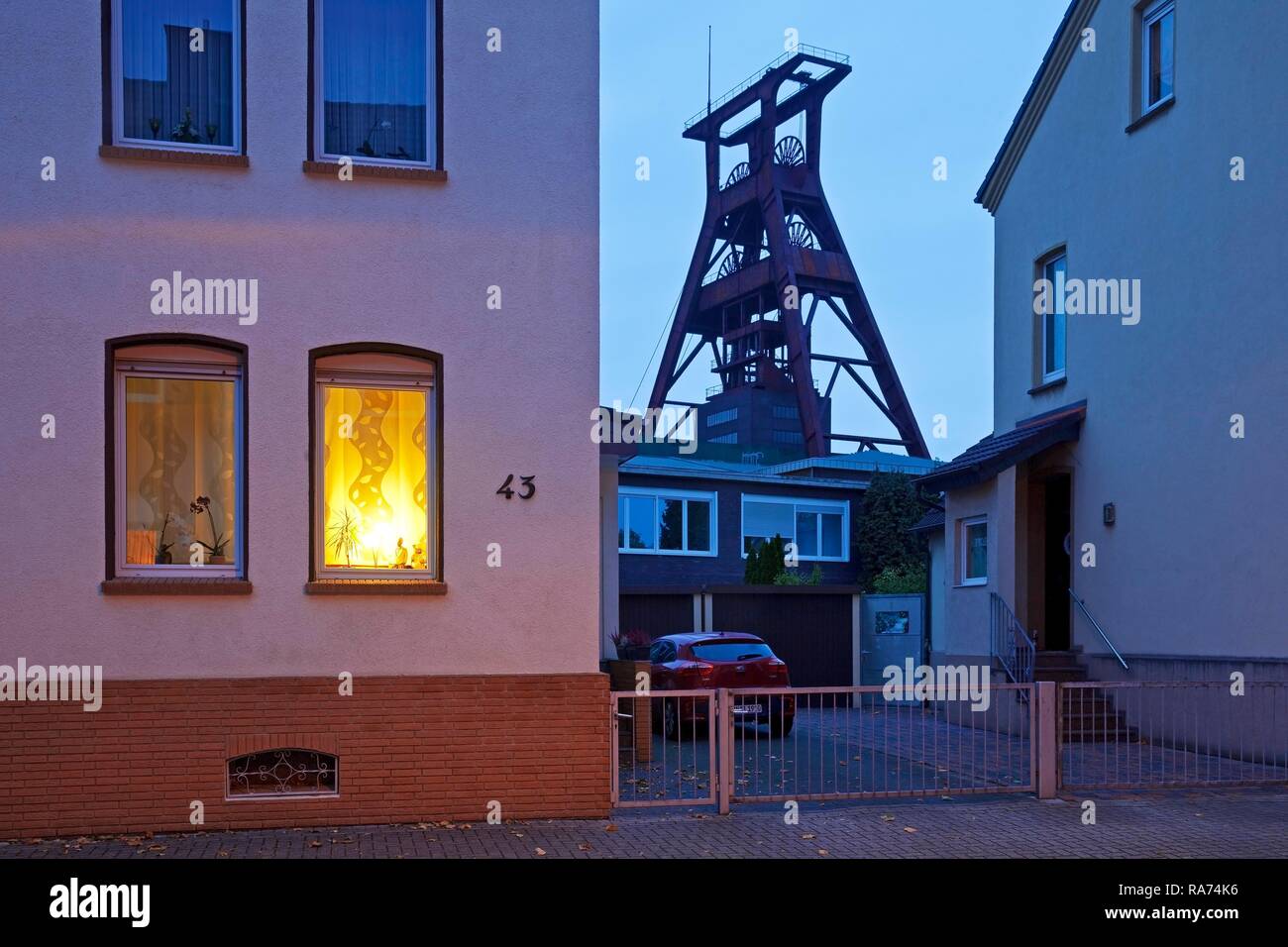 Edifici residenziali con la torre di avvolgimento di Plutone colliery al crepuscolo, Herne, il cambiamento strutturale, la zona della Ruhr Foto Stock