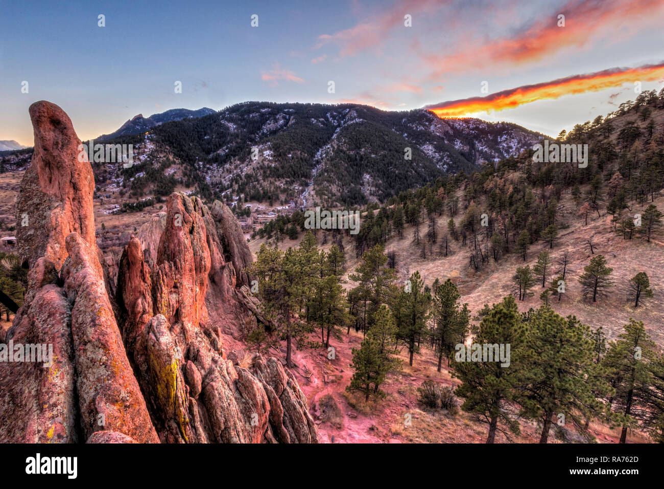 L'inverno il sole tramonta dietro la montagna di Flagstaff, visto dalla parte superiore della Roccia Rossa in alette di coloni' Park di Boulder, in Colorado. Foto Stock