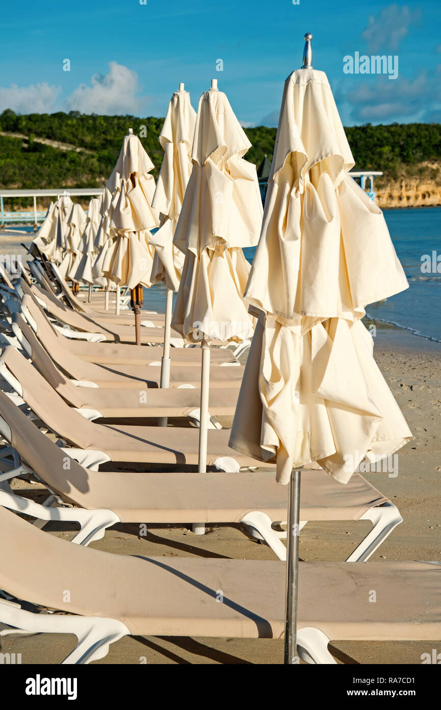 Sdraio e ombrelloni sulla spiaggia tropicale in st Johns, Antigua. Vacanze estive sui Caraibi. Tempo libero, svago, prendere il sole, concetto di balneazione Foto Stock