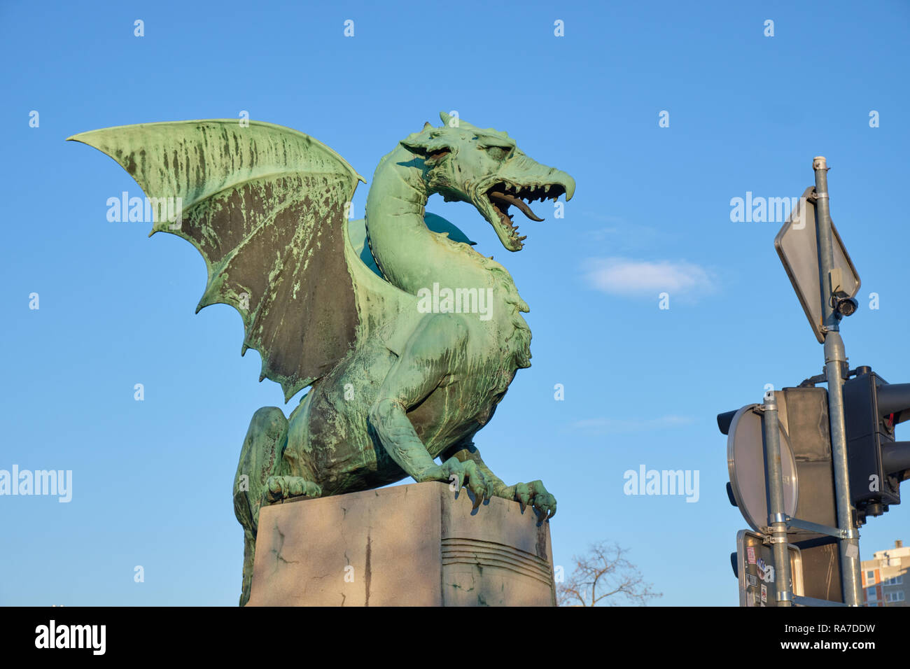 Il drago di fuoco simbolo della città di Lubiana, visto sul ponte della città. Profilo sul cielo blu con nuvole appaiono essere fumo dalla bocca del drago. Foto Stock
