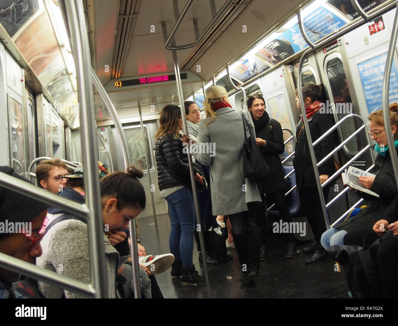 Passeggeri a NYC della metropolitana treno L, ottobre 2018, © Katharine Andriotis Foto Stock
