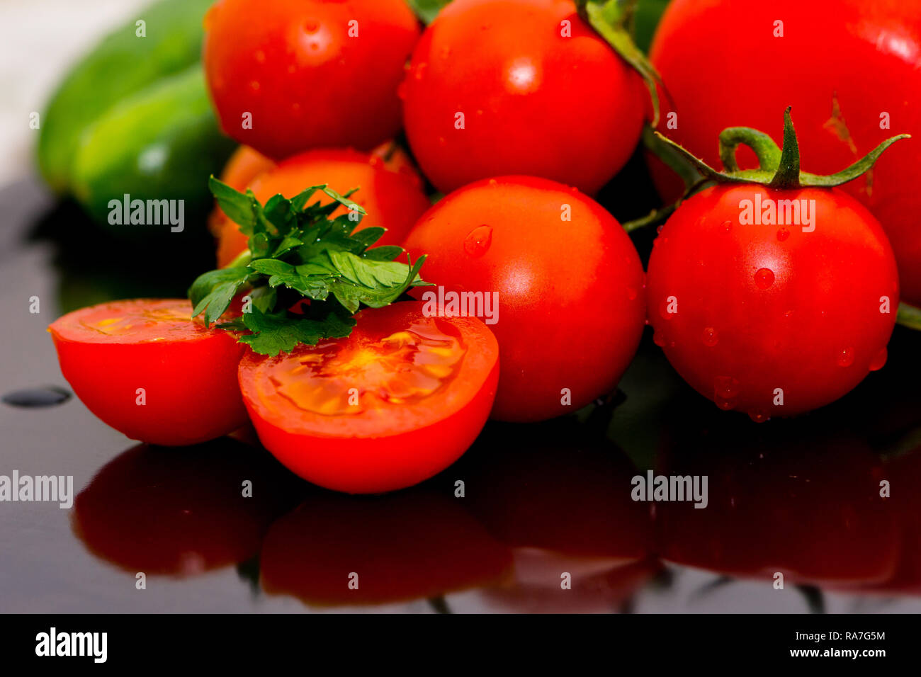 Pomodori, cetrioli e verdure al prezzemolo isolati sul tavolo da cucina pronti per preparare l'insalata Foto Stock