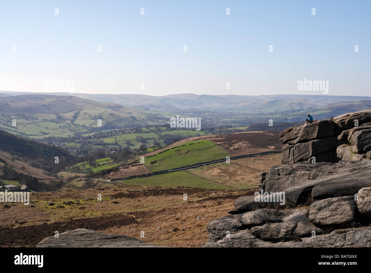 Vista della valle di Hope nel Peak District National Park England UK, da Higger Tor, e scalatore seduto sul paesaggio roccioso Foto Stock