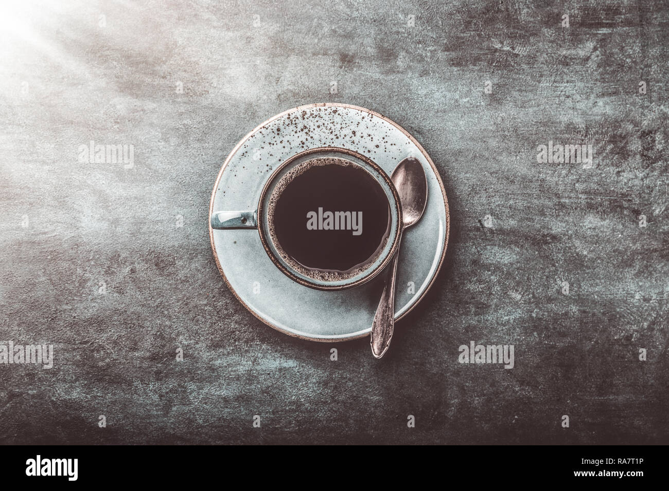 Tazza da caffè su sfondo scuro con un cucchiaio Foto Stock