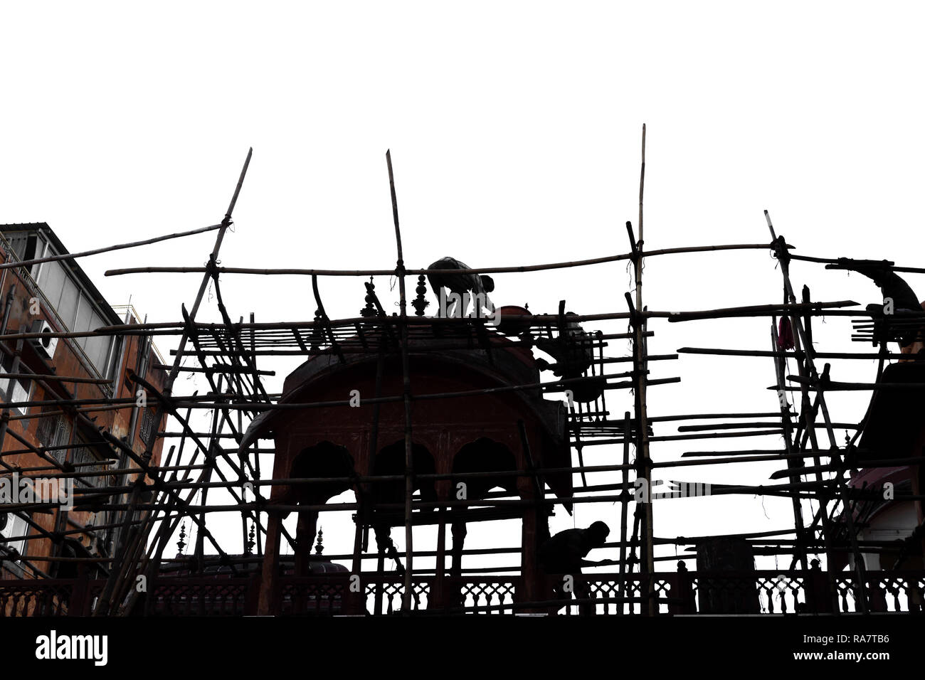 Silhouette Woker sulla impalcatura di bamboo lavorando sulla costruzione di costruzione sito. Foto Stock